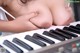 A woman is playing a keyboard with her hands on the keys.