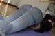 A woman laying on a yoga mat with her legs crossed.