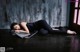 A woman laying on the floor in front of a wooden wall.