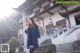 A woman in a blue coat standing in front of a building.