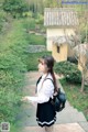 A woman in a school uniform is walking down some steps.