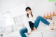 A woman sitting on top of a white counter in a kitchen.