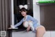 A woman in a bunny costume is posing in the kitchen.