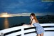 A woman in a blue and white dress standing on a balcony.