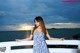 A woman in a blue and white dress standing on a balcony.