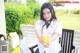 A woman sitting at a table holding a glass of orange juice.