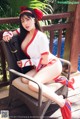 A woman in a red and white outfit sitting on a chair.